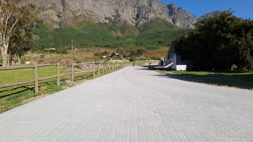 Interlocking block-paved road with mountain backdrop